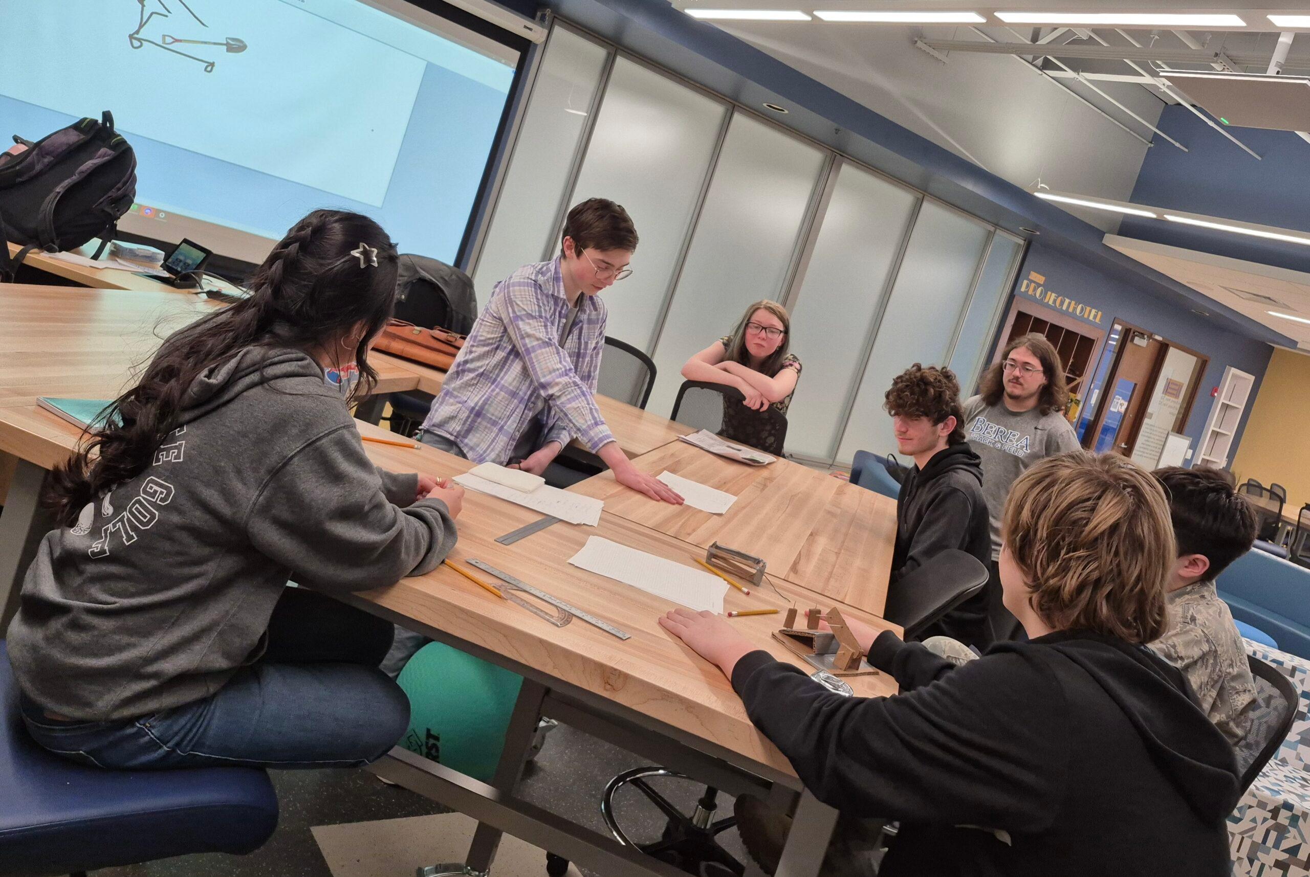The FIRST Robotics team around a collaborative table on campus.