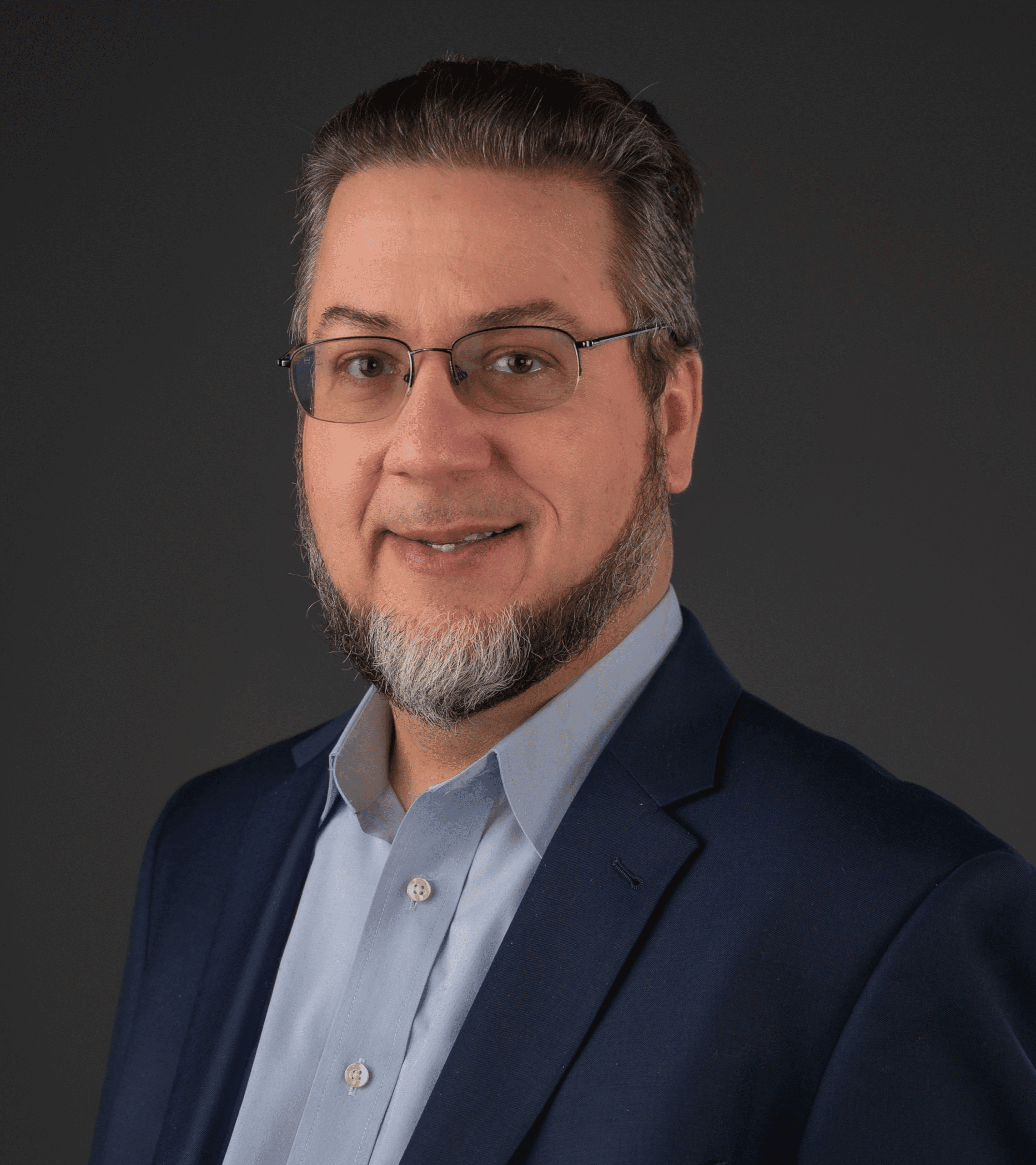 Tim Binkley, head of Special Collections and Archives, posing for a headshot in a blue shirt and dark blue coat jacket.