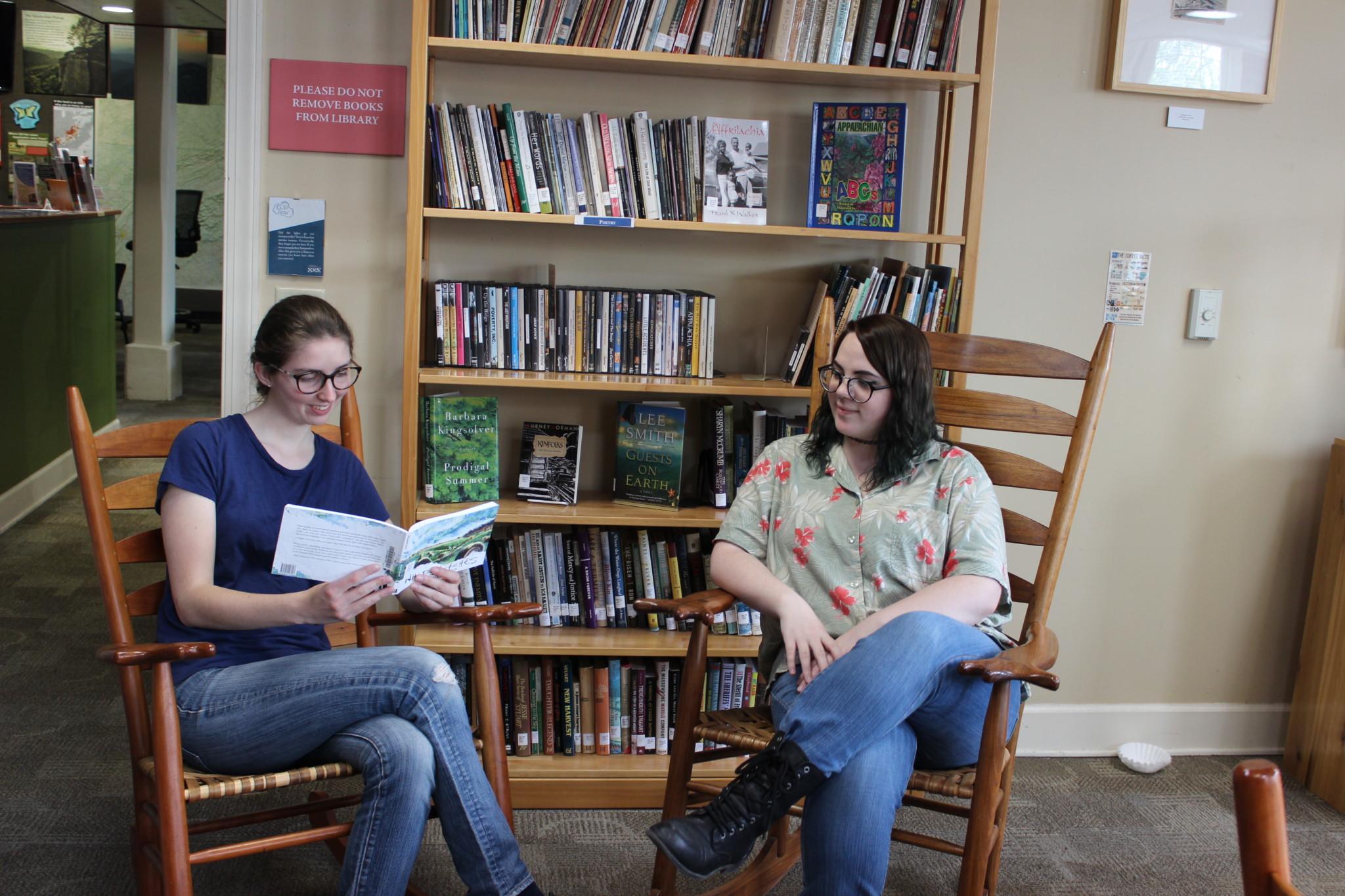 A picture of two students reading a book.